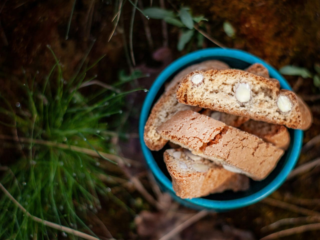 Piattino di cantucci alle mandorle accanto a un bicchierino di Vin Santo ambrato