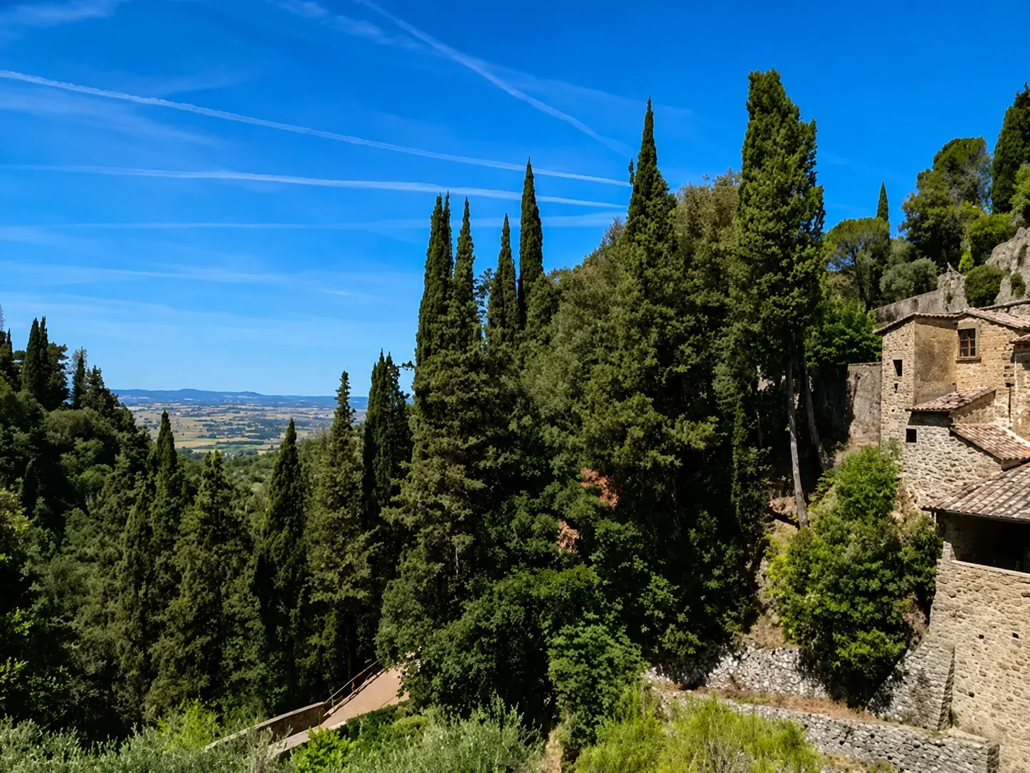 Pellegrini in cammino su un antico sentiero nel paesaggio toscano