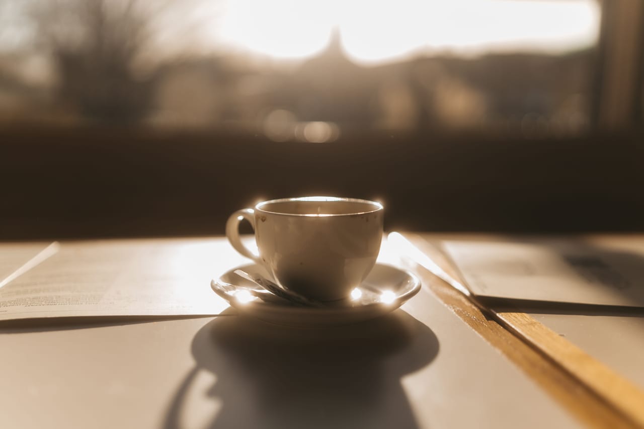 Colazione lenta a un tavolino in un caffè del centro storico di Cortona nella luce del mattino