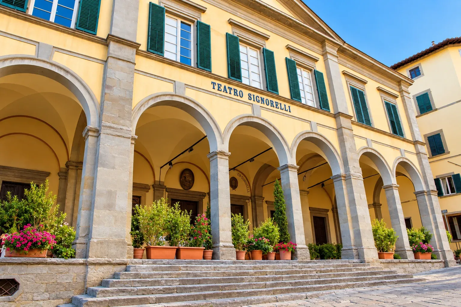 Facciata neoclassica del Teatro Signorelli di Cortona con la loggia a sette arcate che si affaccia sulla piazza