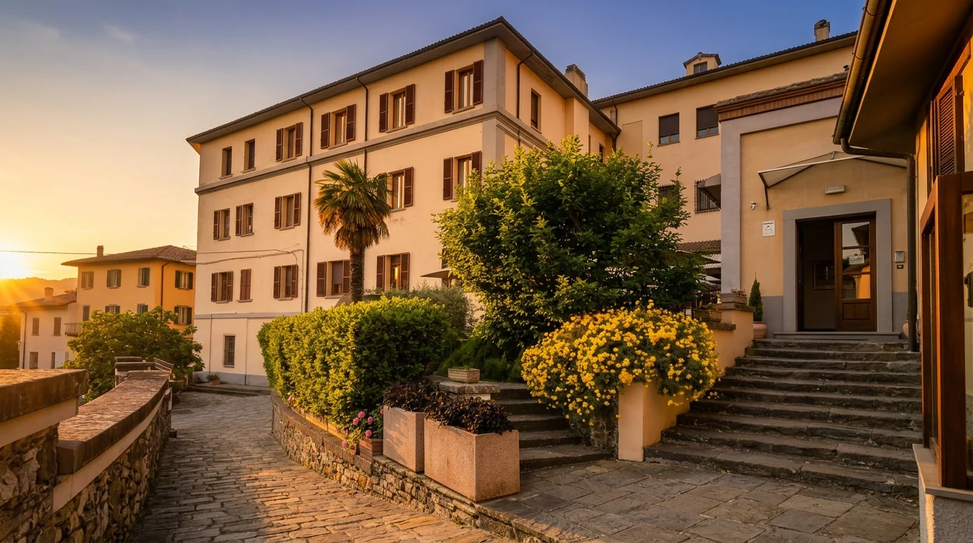 L'esterno dell'Hotel Villa Santa Margherita nel centro di Cortona: facciata e cortile fiorito nella luce calda del tramonto